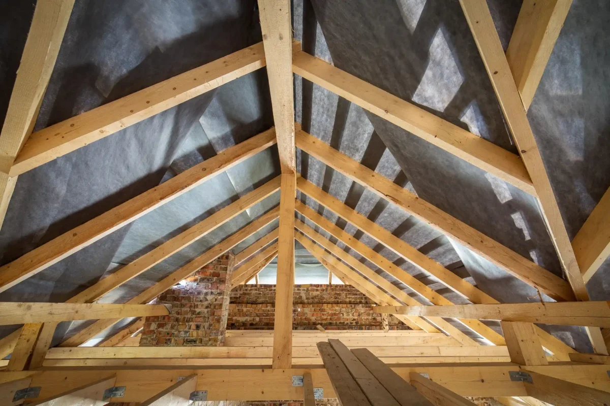 Drewniana więźba dachowa wewnątrz budynku z zamontowaną folią paroprzepuszczalną